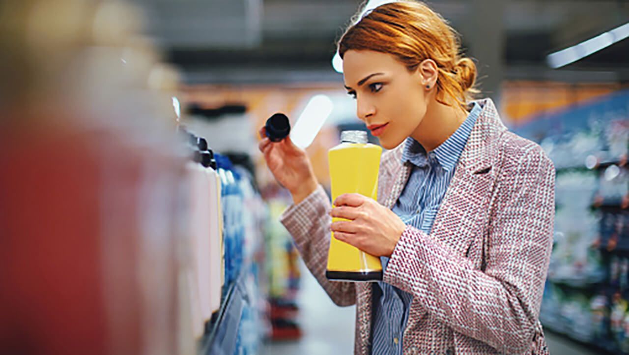 A person smelling a bottle of shampoo