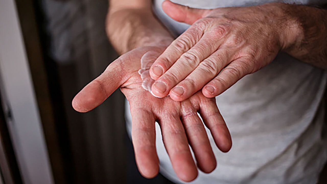 A person rubbing cream into their hands
